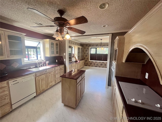 kitchen with white appliances, wallpapered walls, a kitchen island, crown molding, and a sink