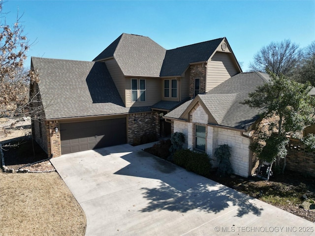 view of front of property featuring a garage, a shingled roof, concrete driveway, and brick siding