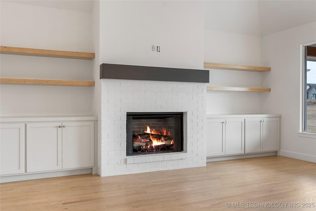 unfurnished living room with light wood-style flooring and a fireplace