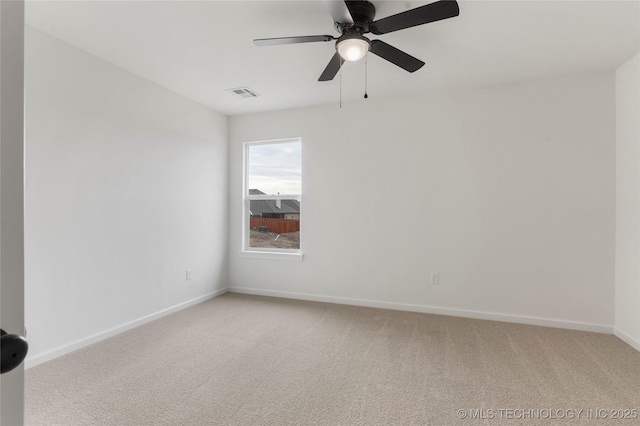 spare room featuring baseboards, ceiling fan, visible vents, and light colored carpet