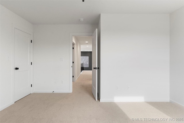 carpeted empty room with baseboards