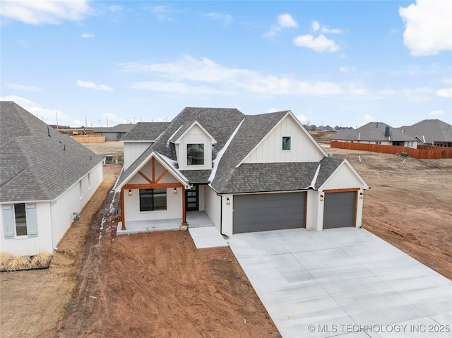 modern farmhouse featuring roof with shingles, concrete driveway, board and batten siding, fence, and a garage