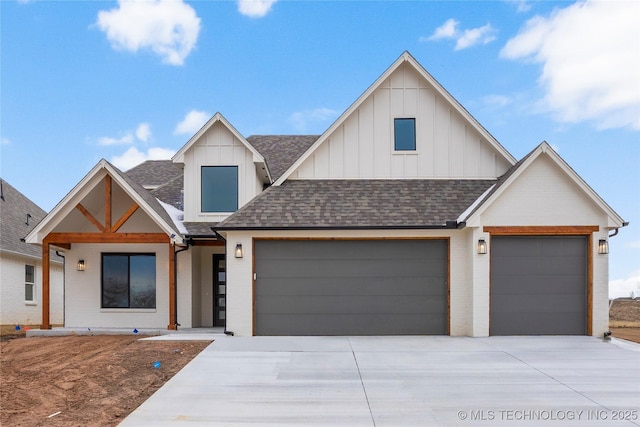 view of front of property featuring an attached garage, driveway, board and batten siding, and roof with shingles