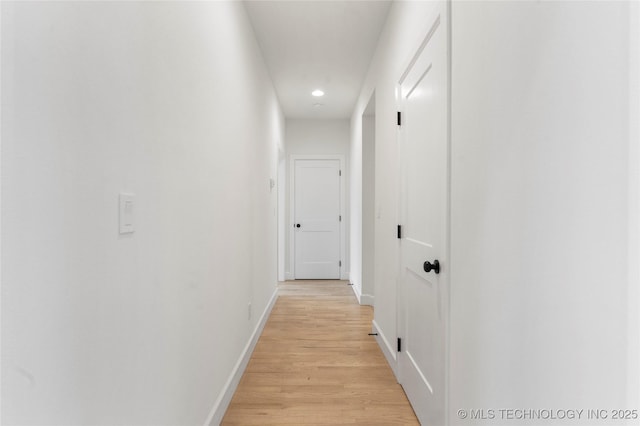 corridor with light wood-type flooring, baseboards, and recessed lighting