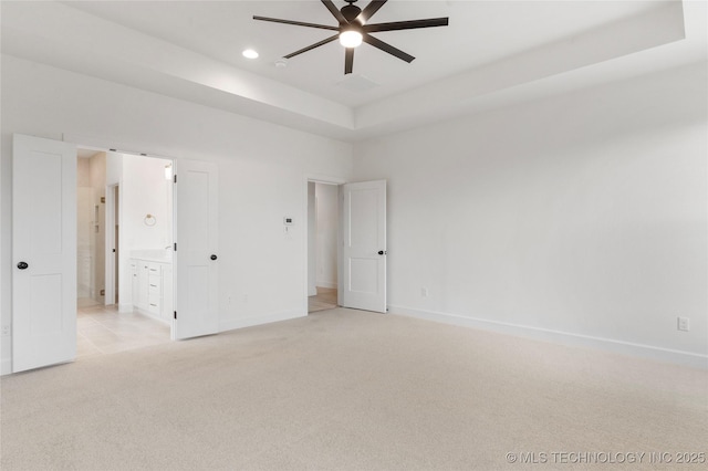 spare room with light carpet, baseboards, a raised ceiling, a ceiling fan, and recessed lighting