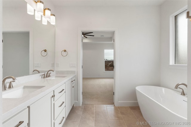 bathroom with a freestanding tub, tile patterned flooring, and a sink