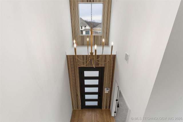 doorway with visible vents, a notable chandelier, and wood finished floors