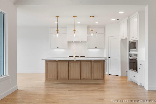 kitchen with stainless steel appliances, light wood finished floors, light countertops, and white cabinets