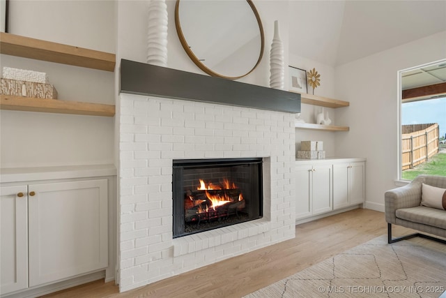 room details featuring a brick fireplace and wood finished floors