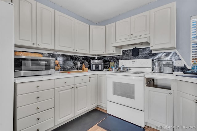 kitchen with light countertops, decorative backsplash, white cabinets, white appliances, and under cabinet range hood