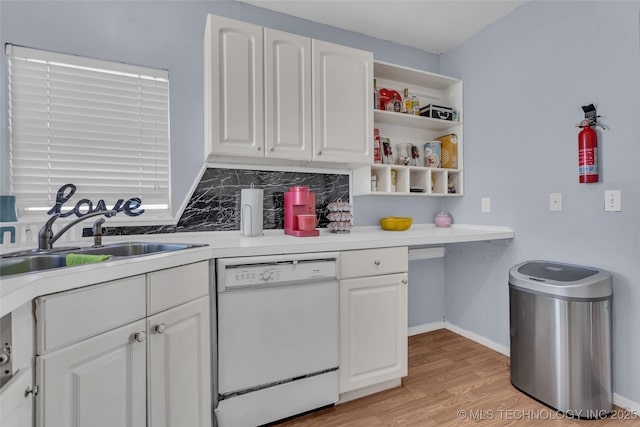 kitchen featuring dishwasher, a sink, light wood-style flooring, and white cabinets