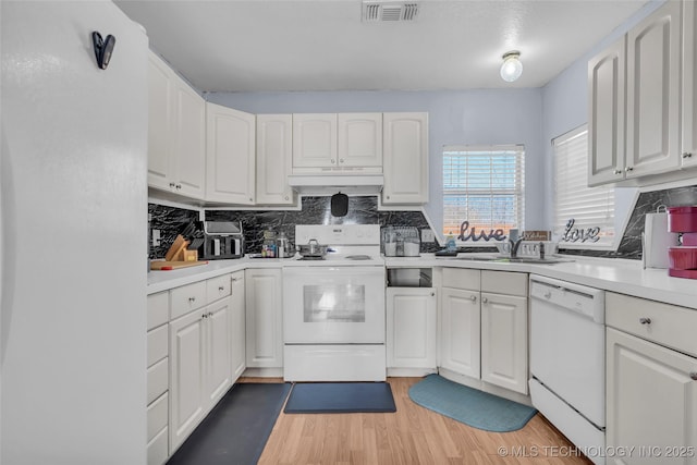 kitchen with light countertops, visible vents, white cabinets, white appliances, and under cabinet range hood