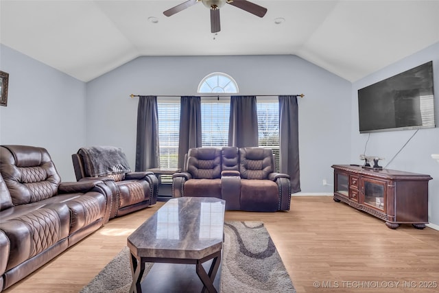 living room featuring light wood-style floors, baseboards, vaulted ceiling, and a ceiling fan