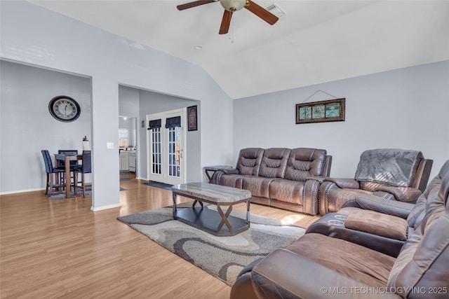 living room with visible vents, ceiling fan, vaulted ceiling, wood finished floors, and baseboards