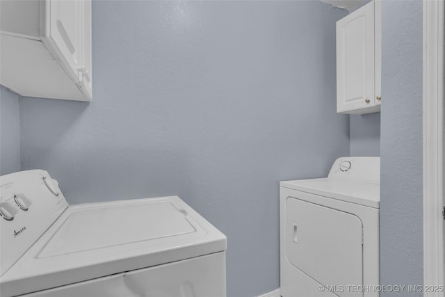 clothes washing area with cabinet space and separate washer and dryer