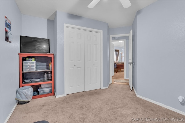 carpeted bedroom featuring a closet, ceiling fan, and baseboards