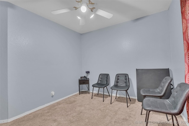 sitting room with carpet floors, baseboards, and a ceiling fan