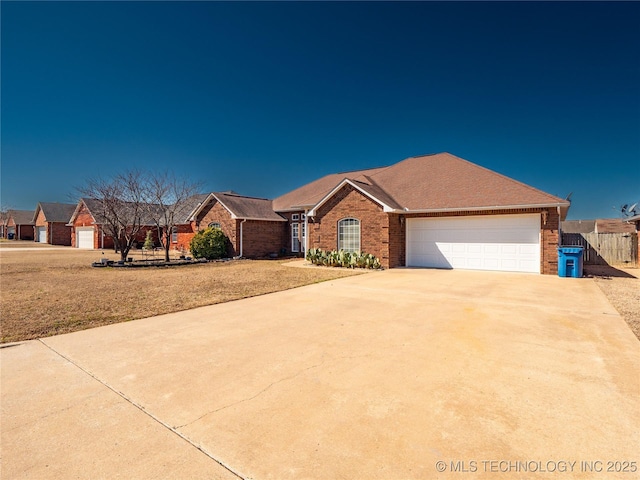 ranch-style house featuring brick siding, driveway, a garage, and fence