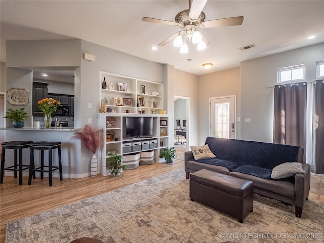 living room with recessed lighting, visible vents, ceiling fan, and light wood-style floors