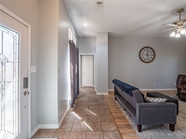 foyer featuring light tile patterned floors, visible vents, baseboards, and ceiling fan