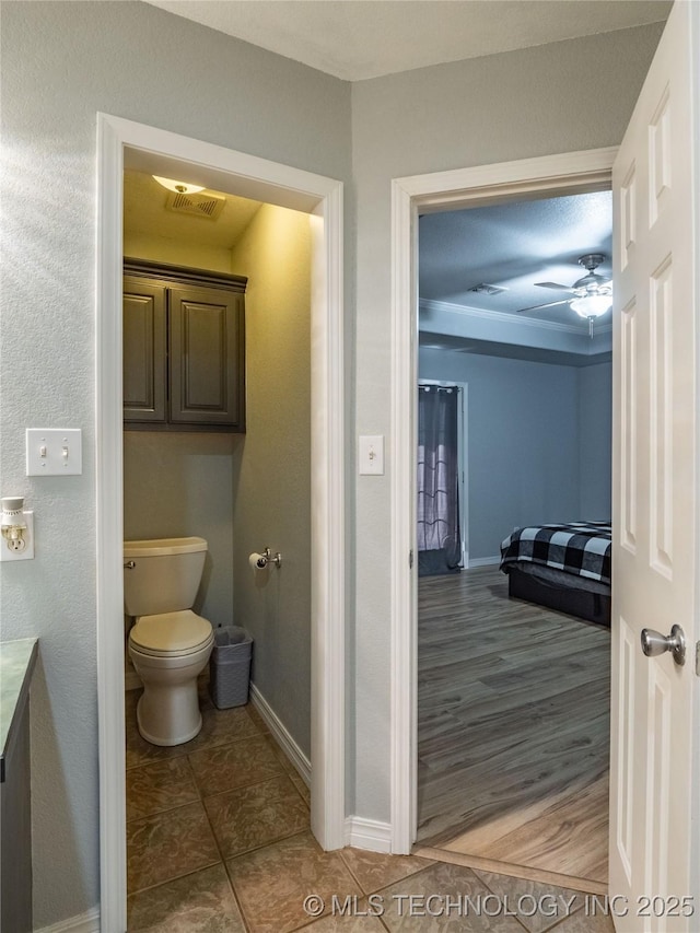 bathroom featuring wood finished floors, baseboards, visible vents, ceiling fan, and toilet