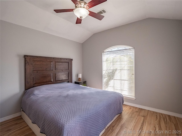 bedroom featuring visible vents, lofted ceiling, and light wood-style floors