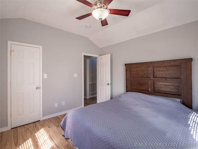 bedroom with light wood finished floors, visible vents, baseboards, and lofted ceiling