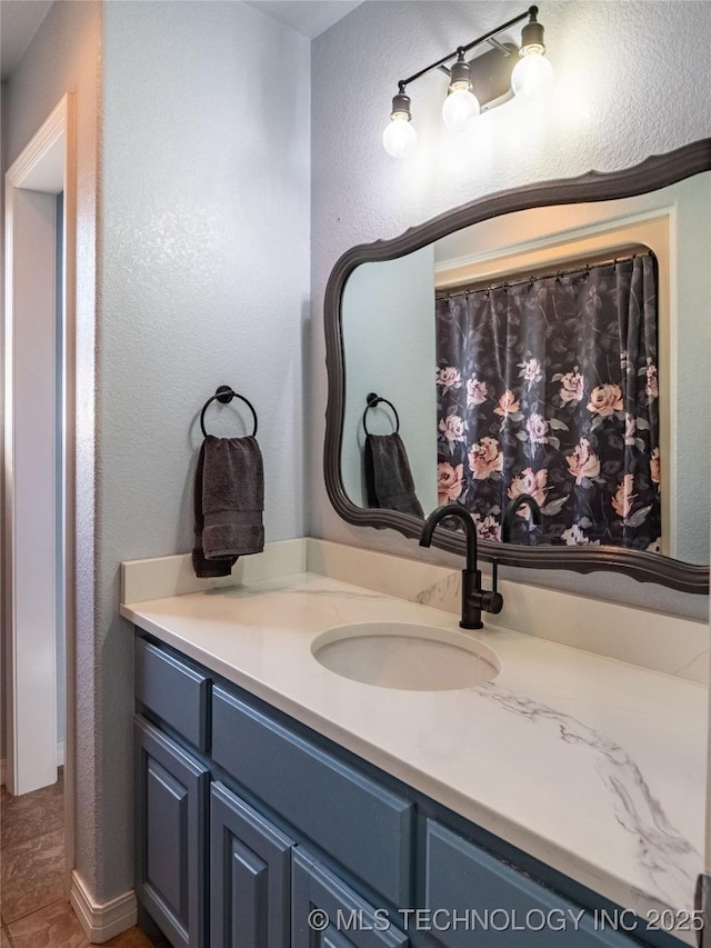 bathroom with vanity and a textured wall