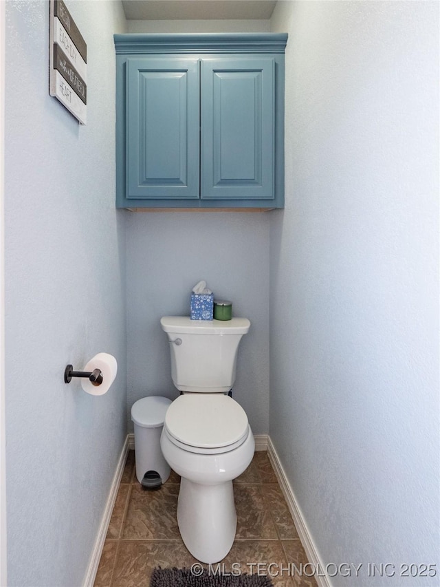 bathroom featuring tile patterned flooring, toilet, and baseboards