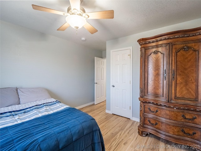 bedroom with baseboards, a ceiling fan, and light wood finished floors