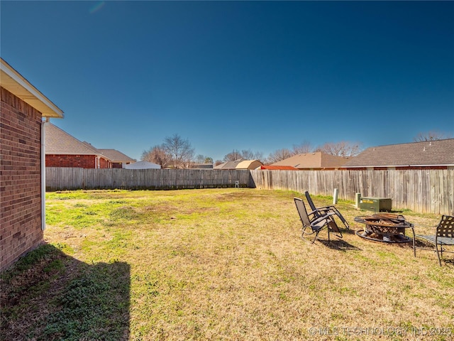 view of yard featuring a fenced backyard and an outdoor fire pit