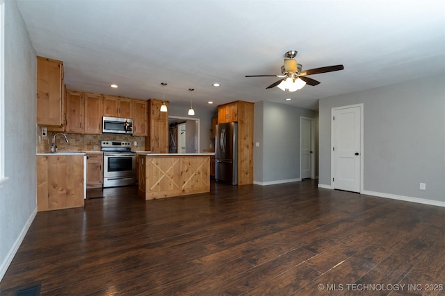 kitchen featuring dark wood-style floors, a center island, stainless steel appliances, light countertops, and open floor plan