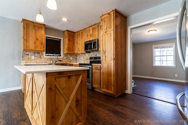 kitchen with dark wood-style floors, tasteful backsplash, appliances with stainless steel finishes, and light countertops