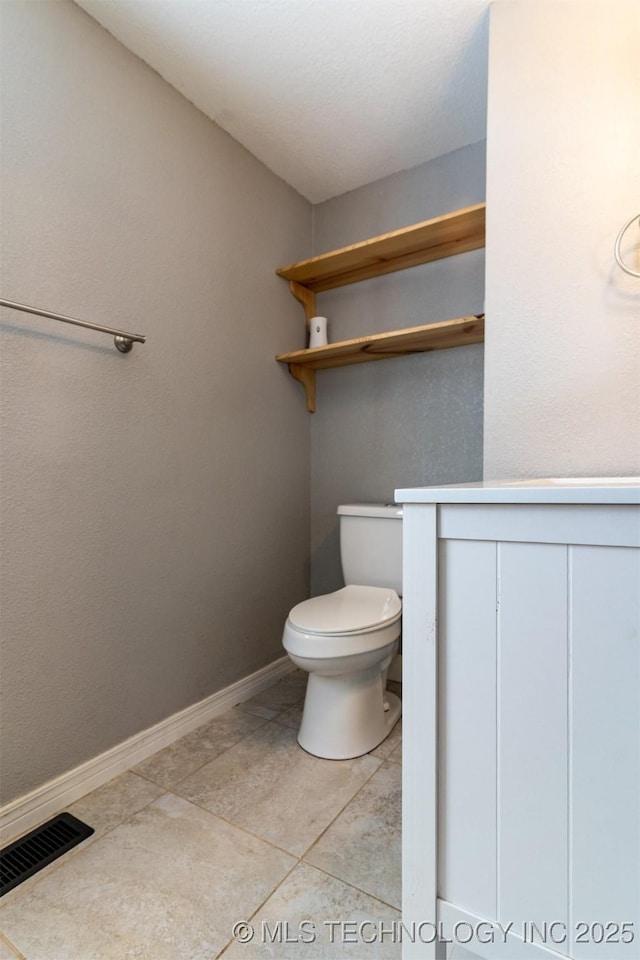 bathroom featuring visible vents, baseboards, toilet, and tile patterned floors