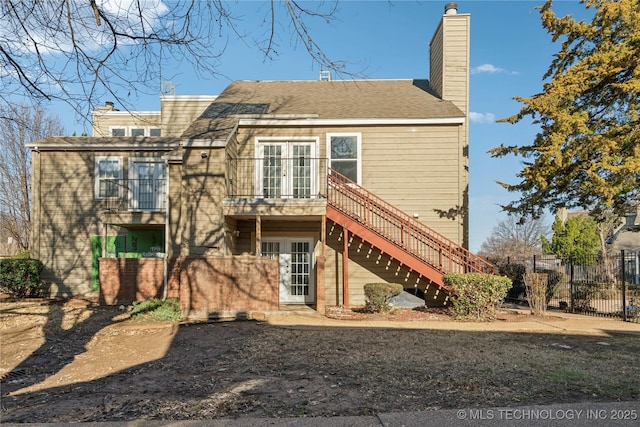 rear view of property with stairs, french doors, a chimney, and fence