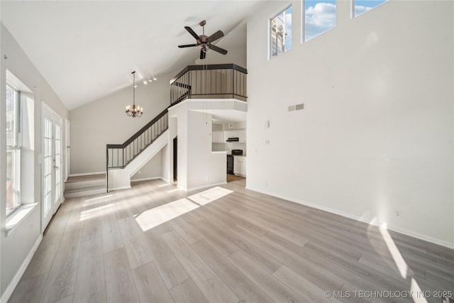 unfurnished living room with light wood finished floors, visible vents, stairway, baseboards, and ceiling fan with notable chandelier