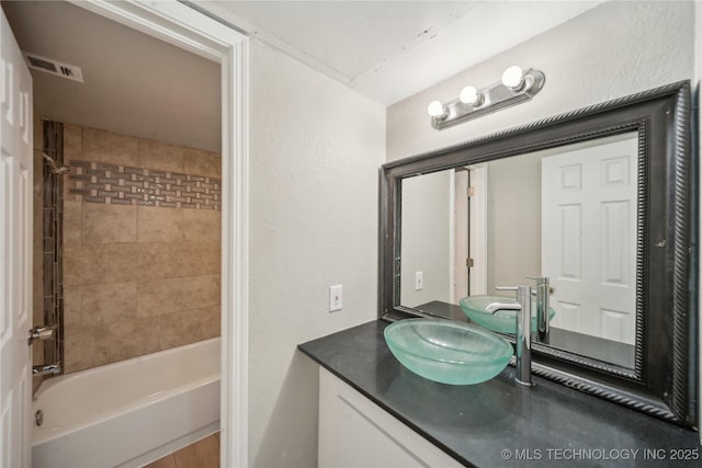 bathroom featuring  shower combination, visible vents, and vanity