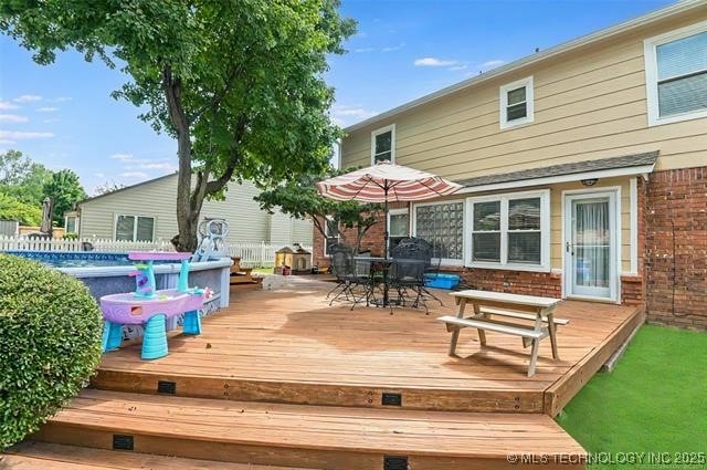 wooden terrace featuring outdoor dining area and an outdoor pool