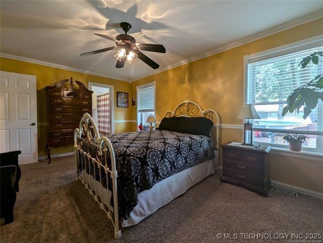 bedroom with ceiling fan, ornamental molding, carpet, and baseboards