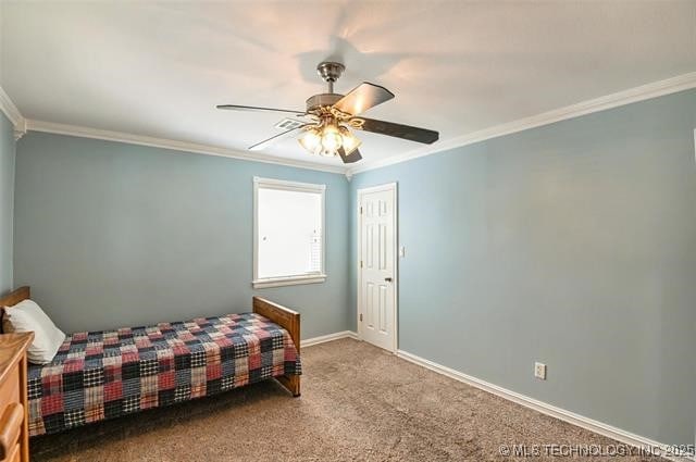 carpeted bedroom featuring crown molding, a ceiling fan, and baseboards