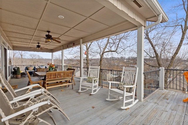 wooden deck with an outdoor living space and a ceiling fan