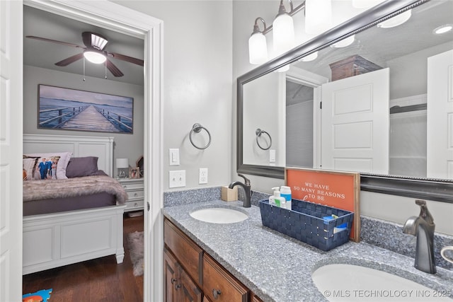 full bath featuring double vanity, a sink, ensuite bath, and wood finished floors