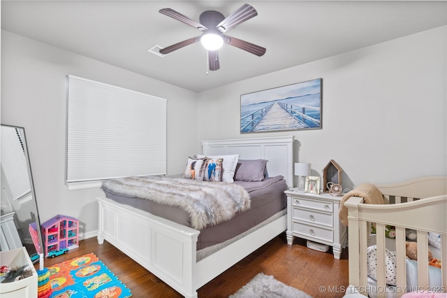 bedroom featuring dark wood-style floors, ceiling fan, and visible vents