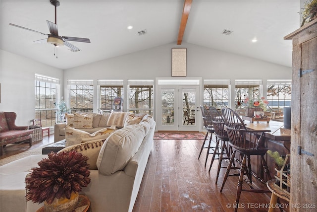 living room with ceiling fan, visible vents, beamed ceiling, and hardwood / wood-style flooring