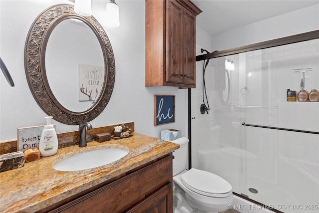 full bathroom with toilet, a shower stall, and vanity