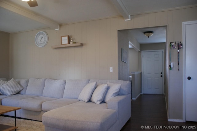 living area featuring beamed ceiling and wood finished floors