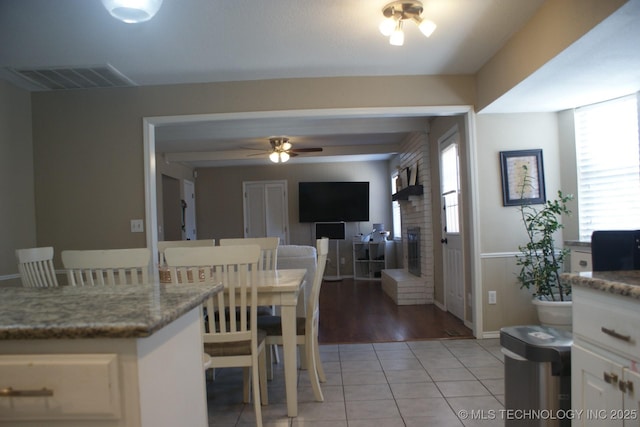 dining room featuring light tile patterned floors, ceiling fan, visible vents, and baseboards