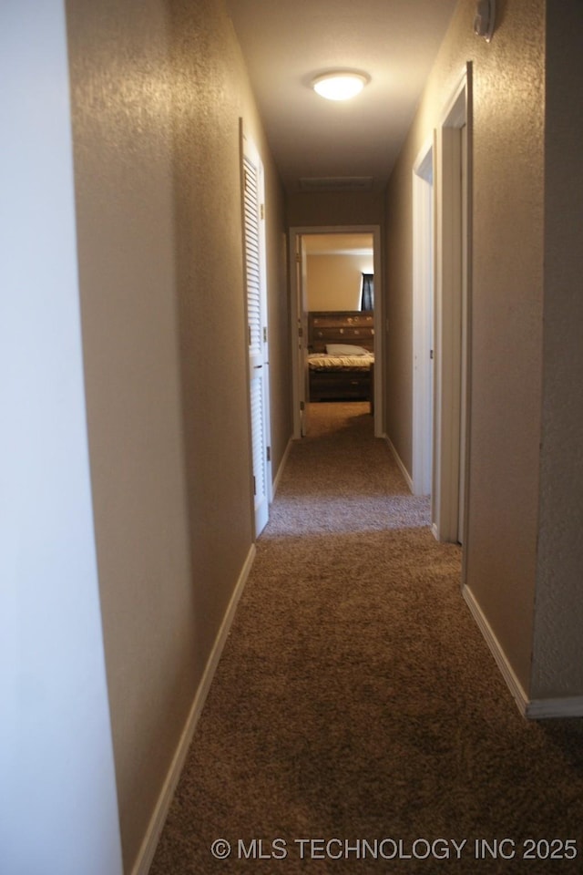 corridor with carpet and baseboards