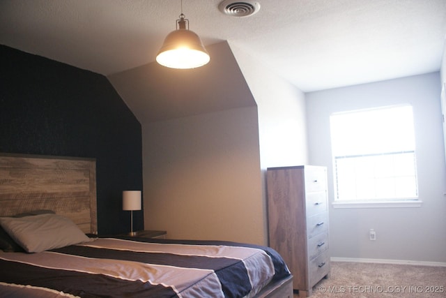 carpeted bedroom with lofted ceiling, visible vents, and baseboards