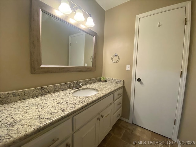 bathroom with stone finish floor and vanity